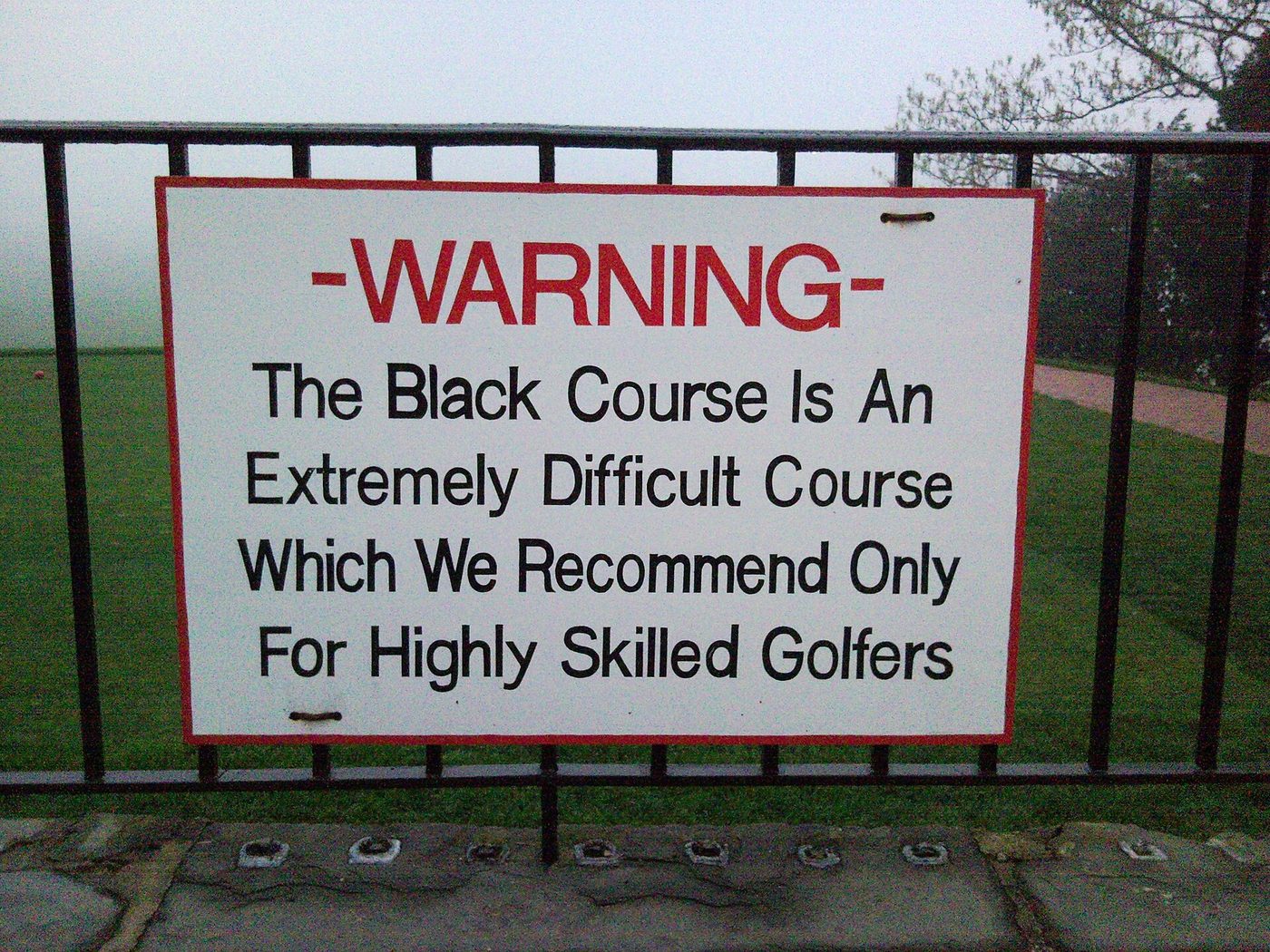 The red-and-white warning sign at Bethpage Black saying the course is recommended only for highly skilled golfers