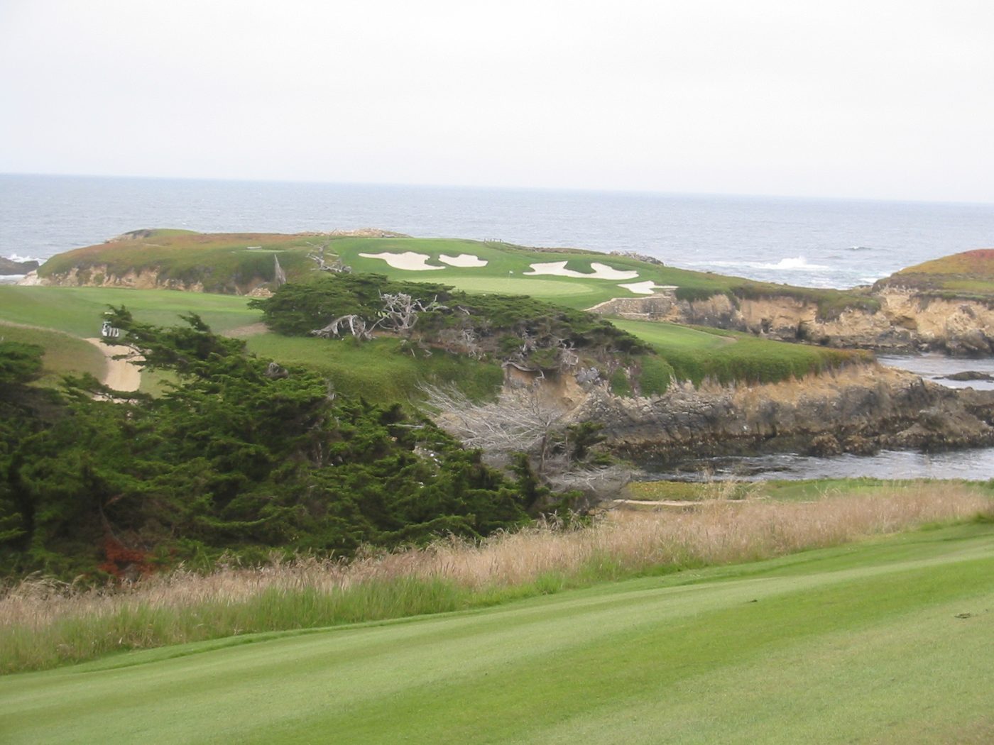 Cypress Point Club's par-3 16th green on a rocky headland above the Pacific
