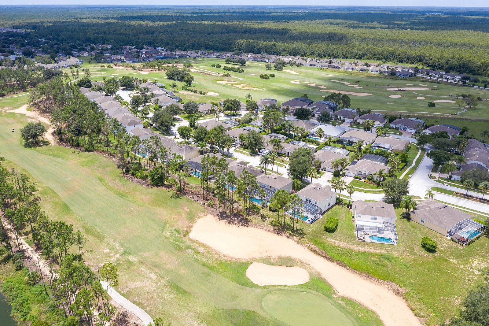 Aerial view of homes with pools lining the fairways of Highlands Reserve Golf Course near Orlando, a typical example of golf course communities in Florida