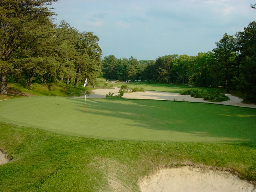 The 17th green at Pine Valley Golf Club in New Jersey, with sandy waste areas and pine forest behind