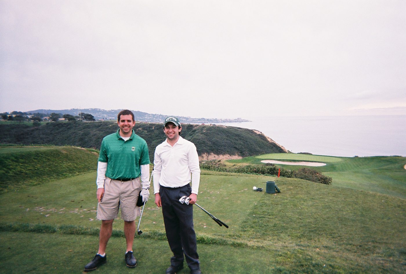 Two golfers on the third tee at Torrey Pines above the Pacific cliffs in La Jolla, San Diego