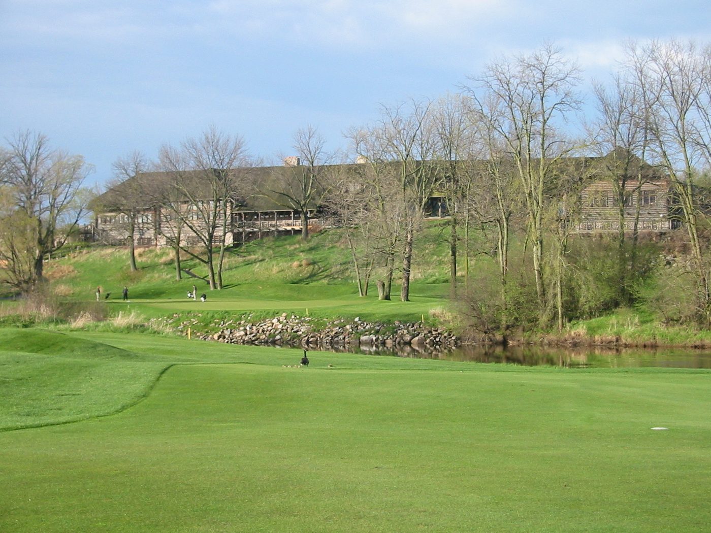 The clubhouse at Blackwolf Run in Kohler on a slope above a green and a pond
