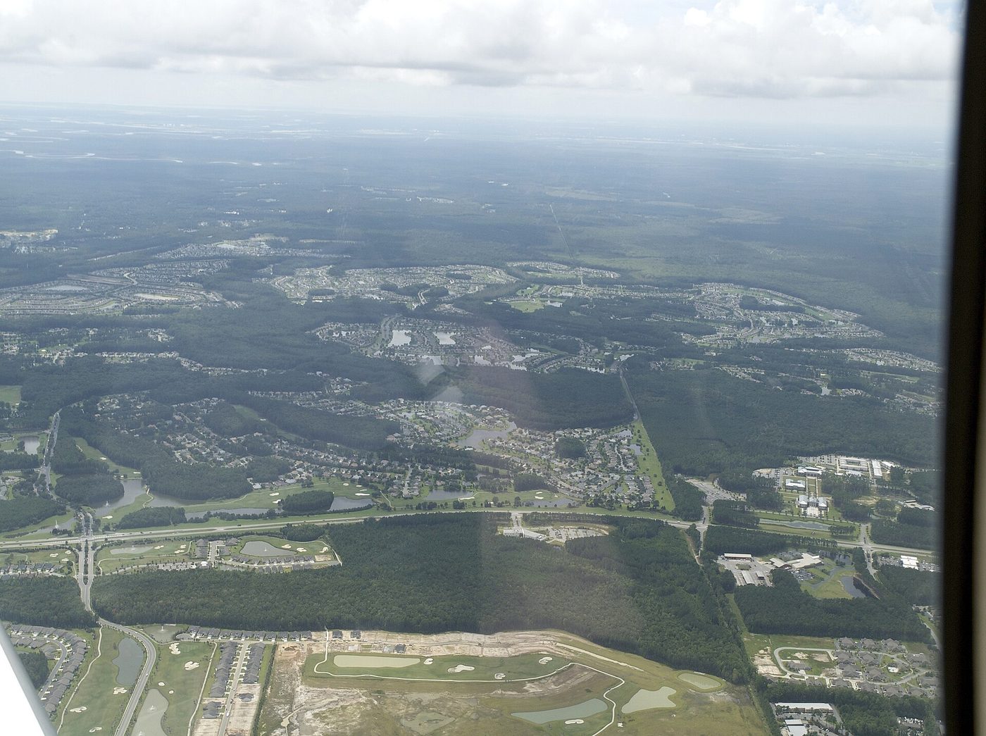 Aerial view of Sun City Hilton Head in Bluffton, South Carolina, from 3,500 feet, with neighbourhoods and golf holes among the pine forest